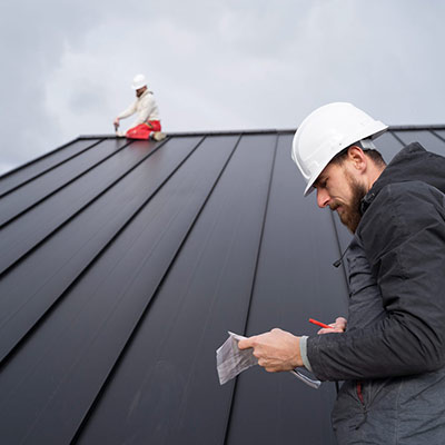 Dachdecker bei der Qualitätskontrolle und Begutachtung eines Metalldachs in Fellbach